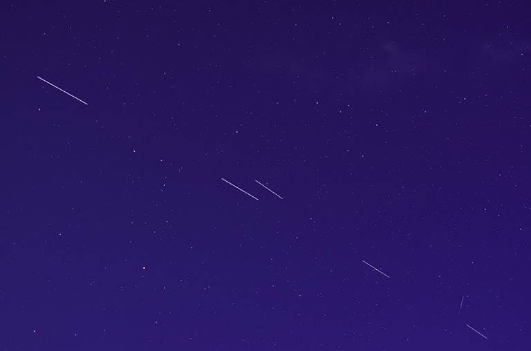 Starlink-Satelliten synchronisieren sich am Himmel.