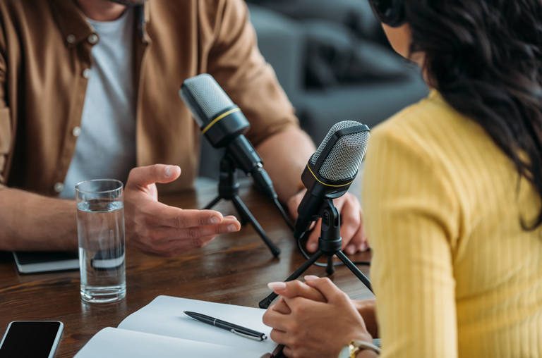 Ein Mann und eine Frau bei der Aufnahme eines Podcasts