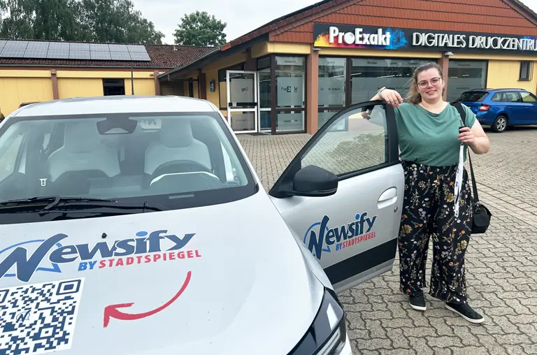 Redakteurin Sophie Weimannmit dem neuen E-Auto für die Nachrichtenplattform Newsify