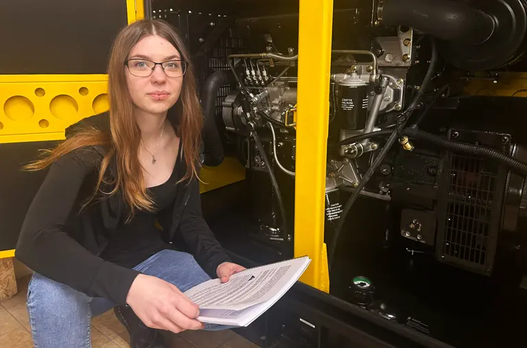 Milena Schlötel vor dem Notstromaggregat von ProExakt